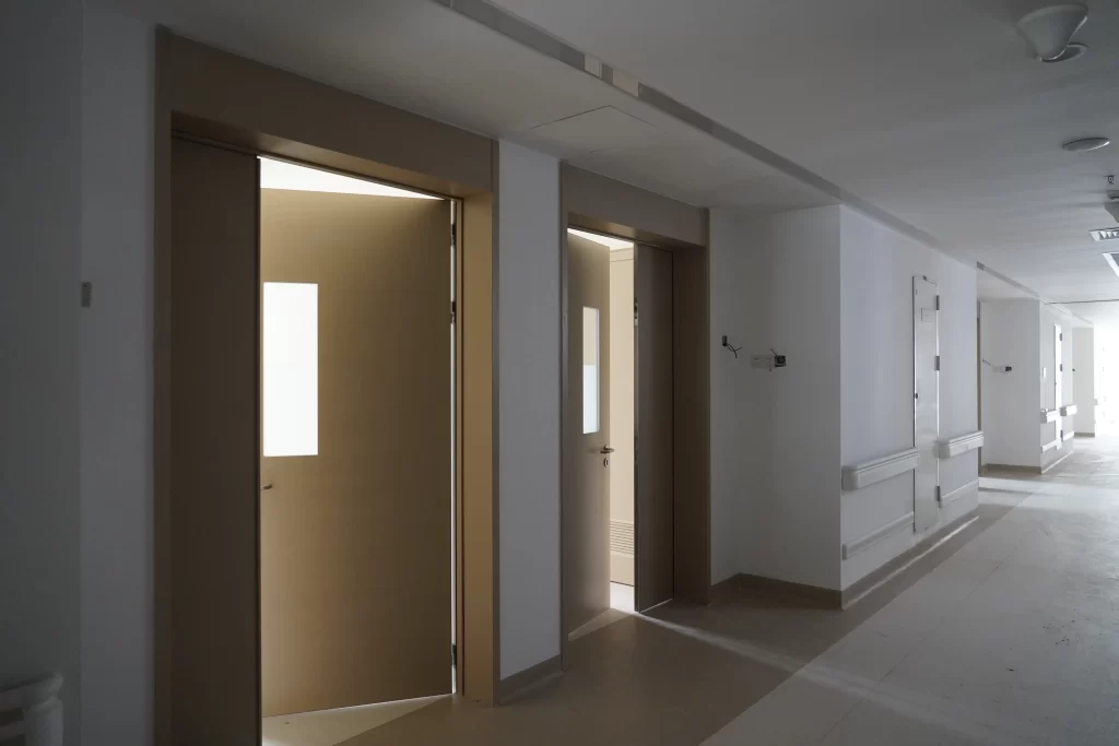 Interior view of a cleanroom corridor in a healthcare setting, featuring partially open airtight doors with modular wall systems.