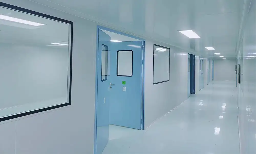 Long bright cleanroom corridor with open blue airtight hermetic swing door for high-grade ISO5-7 core zones, fully sealed wall panels, observation windows, epoxy floor for strict pressure differential control.