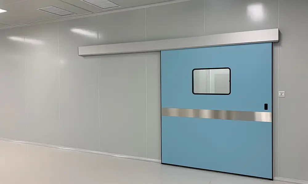 Light blue hermetic sliding door in a GMP cleanroom, with observation window and stainless steel trim.