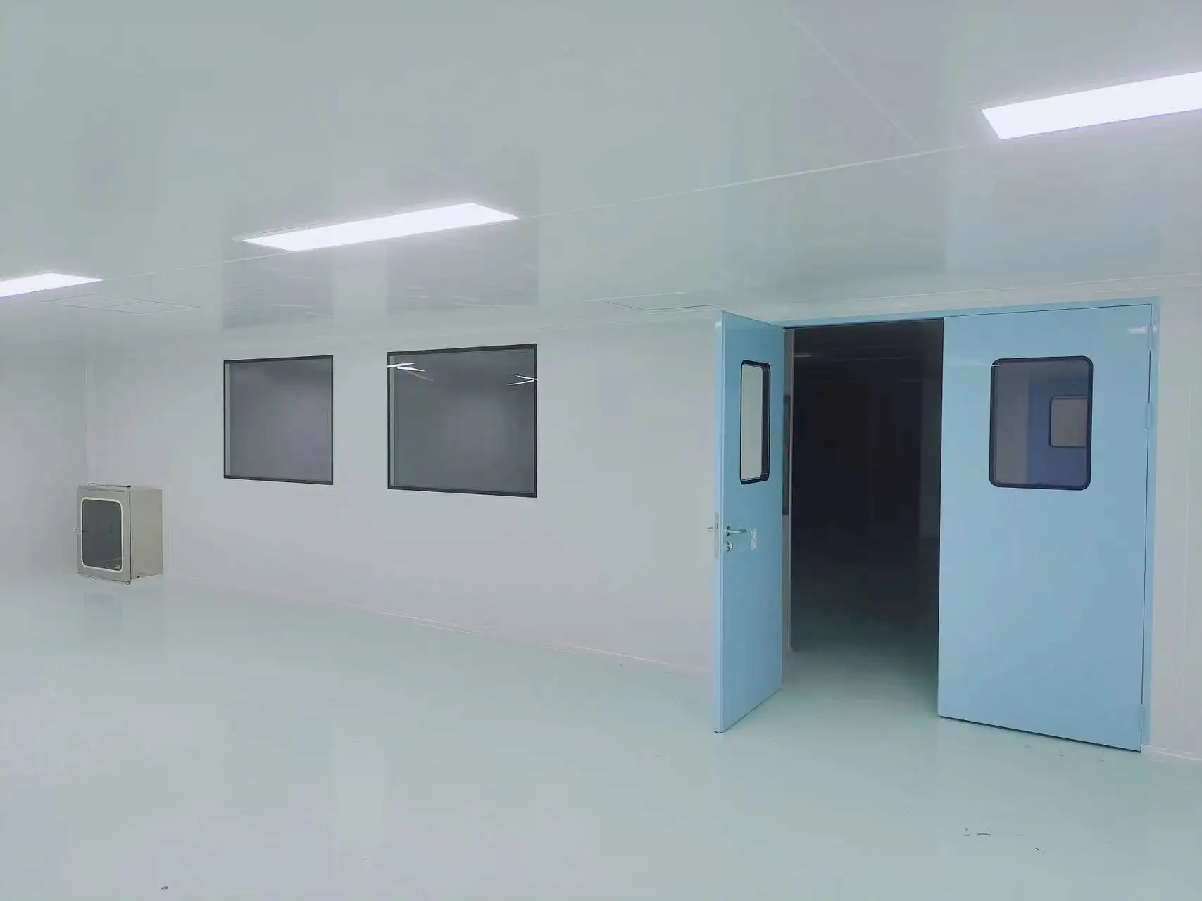 USP cleanroom doors with double swing design and vision panels installed in a bright GMP-compliant cleanroom environment.