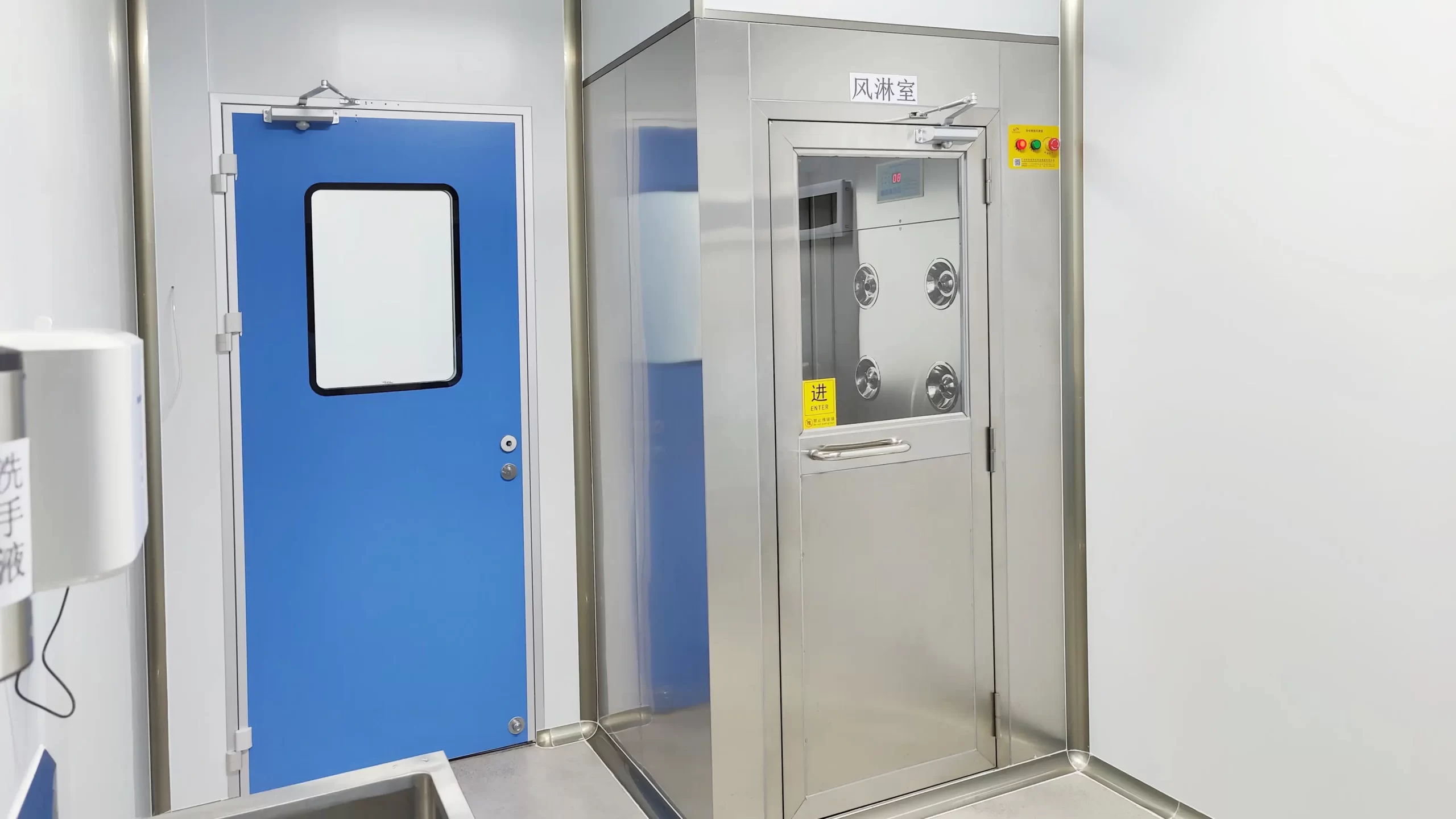 Biotech cleanroom gowning area featuring Cleanroom pass door paired with stainless air shower interlock chamber, flush vision window, concealed hinges, compliant ISO 7 gowning prep zone.