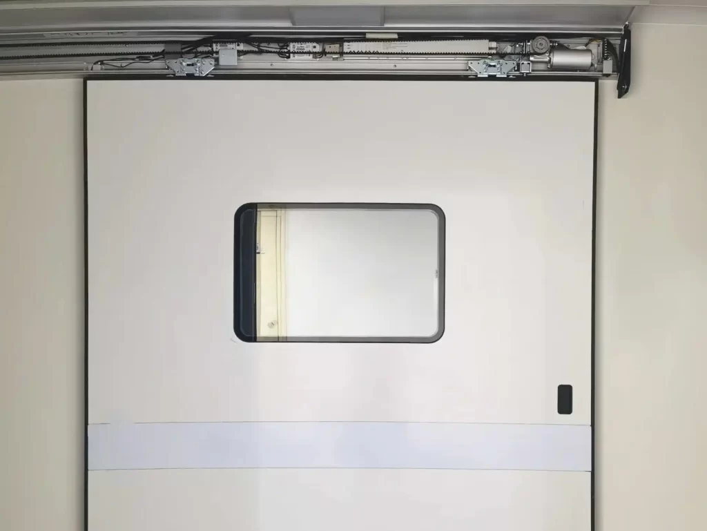 Top-hung cleanroom automatic sliding door with view window and exposed overhead drive motor mechanism