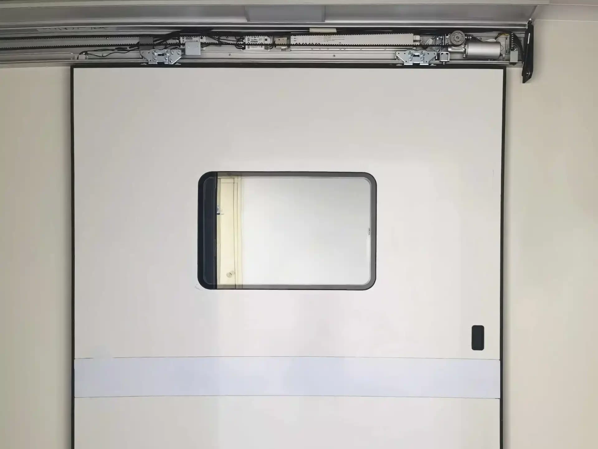 Top-hung cleanroom automatic sliding door with view window and exposed overhead drive motor mechanism