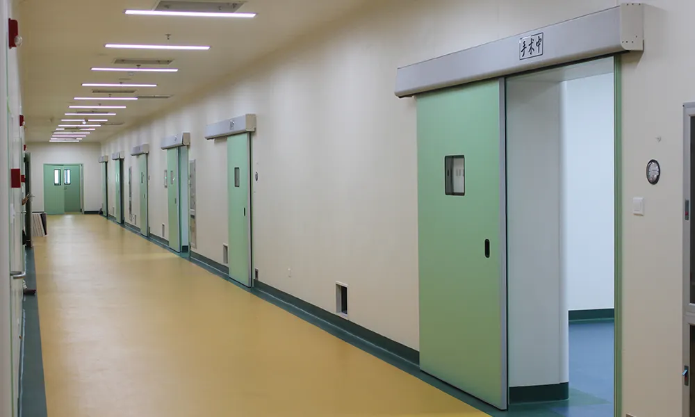 Automatic green hospital sliding doors installed along a wide clean corridor for operating suites and clinical areas